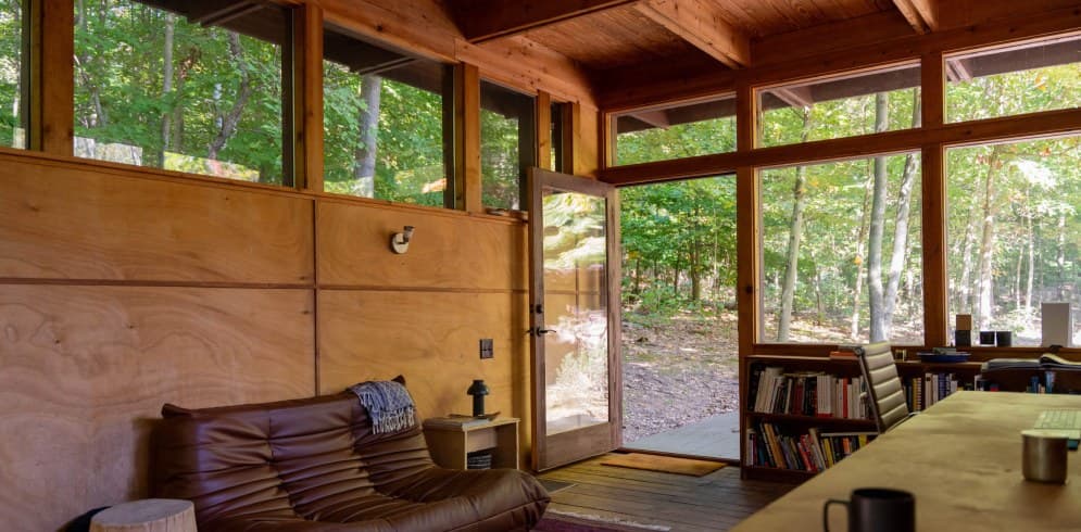 The studio: a wood-paneled room with windows onto the forest